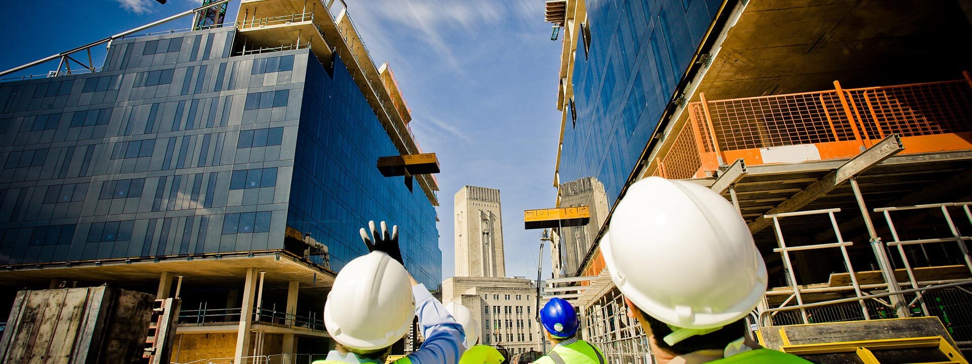 Construction workers looking up at a building site above